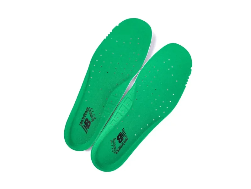 Green foam shoe insoles with ventilation holes and branding details.