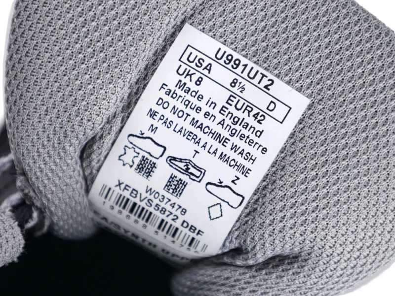 Close-up of a gray mesh fabric shoe with care label insole.