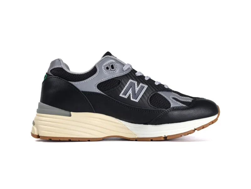 Black and gray leather and mesh sneaker with beige cushioned sole.