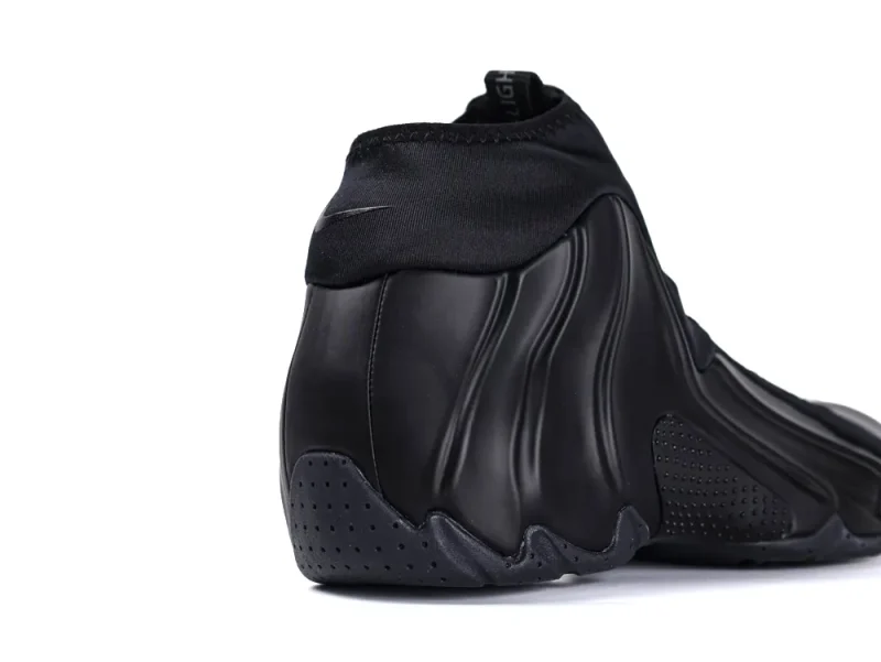 Sleek black synthetic shoe with textured sole and smooth upper material.