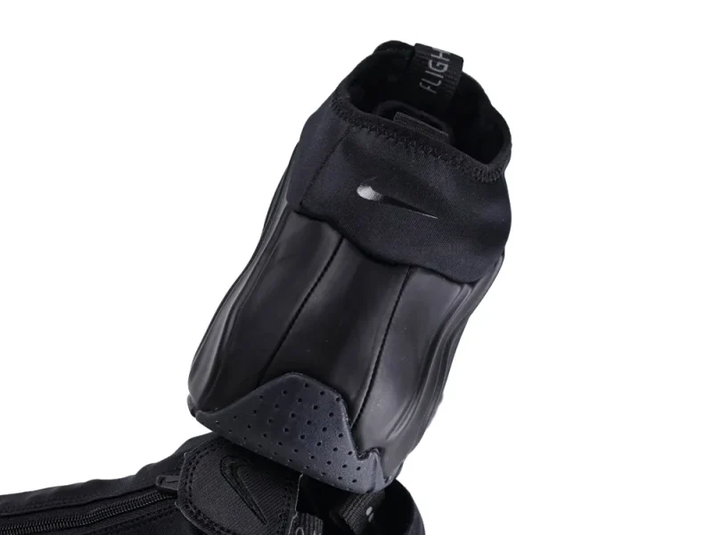 Black synthetic shoe with rubber upper and fabric ankle collar details.