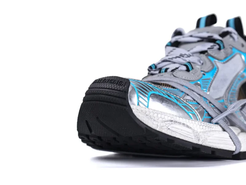 Silver and blue sneaker with black sole, featuring synthetic and rubber materials.