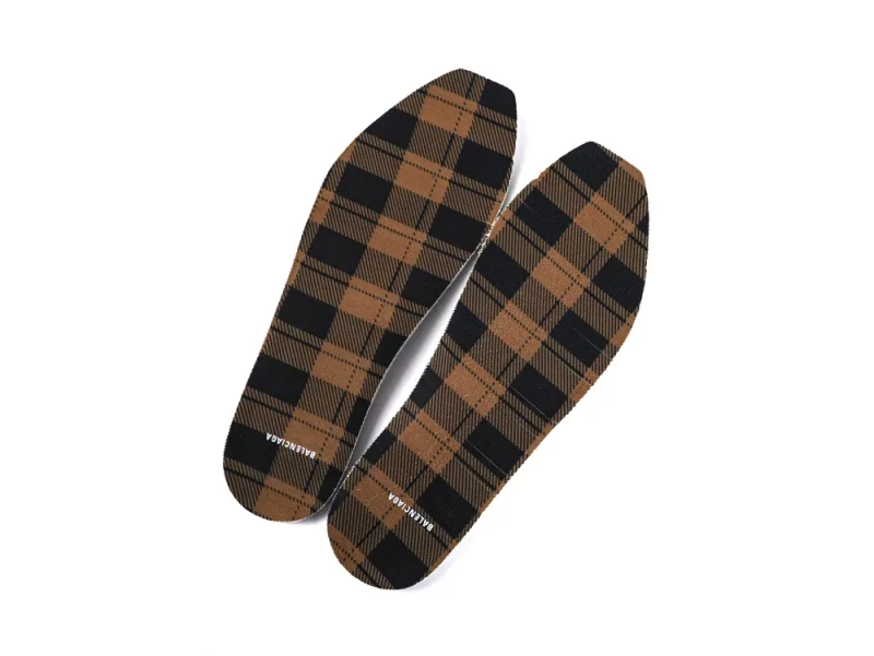 Brown plaid fabric insoles with black accents, Balenciaga branding on surface.