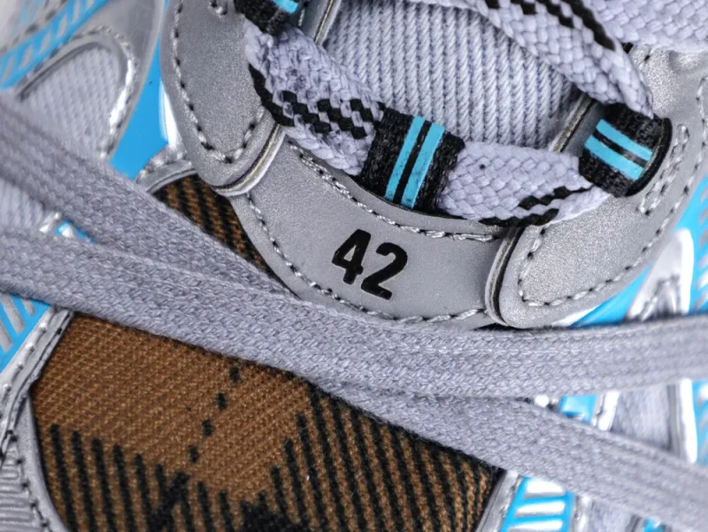 Close-up of a multicolored sneaker with gray laces and silver accents. Size 42.
