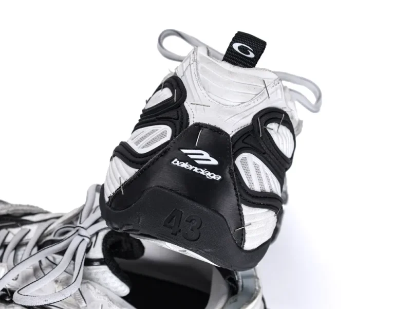 White and black sneaker with mesh material and rubber sole, featuring brand logo.