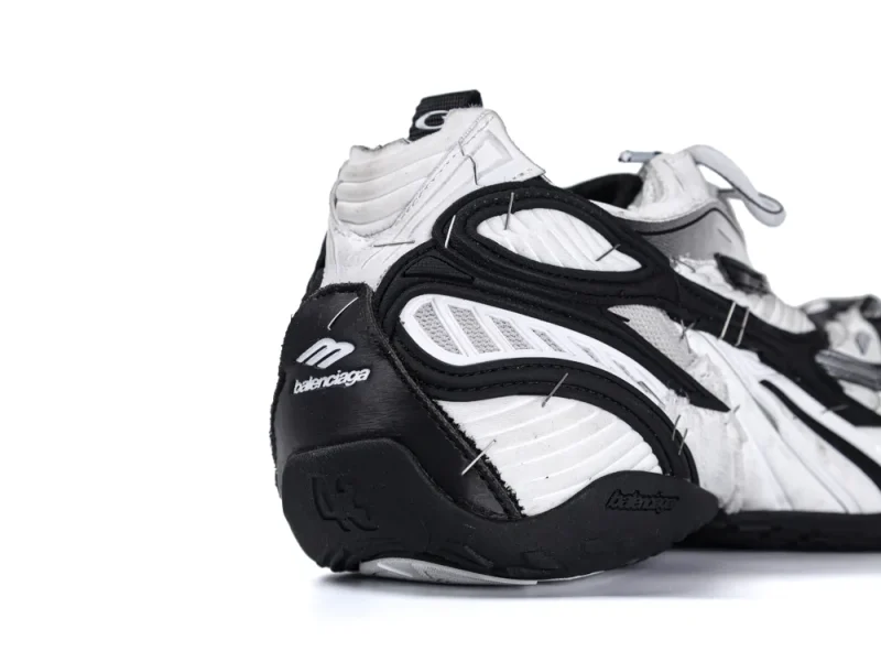 Black and white sneaker with stitched leather and mesh design, featuring side branding.