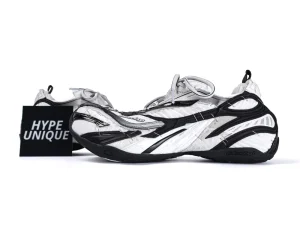 Black and white sneakers with mesh and synthetic material, featuring a distinctive layered design.