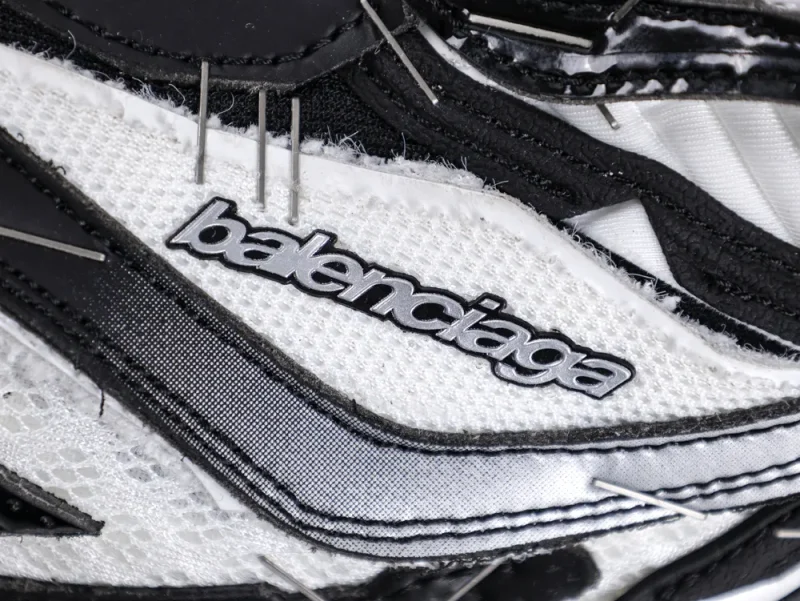 Close-up of a black and white mesh sneaker with a prominent logo detail.
