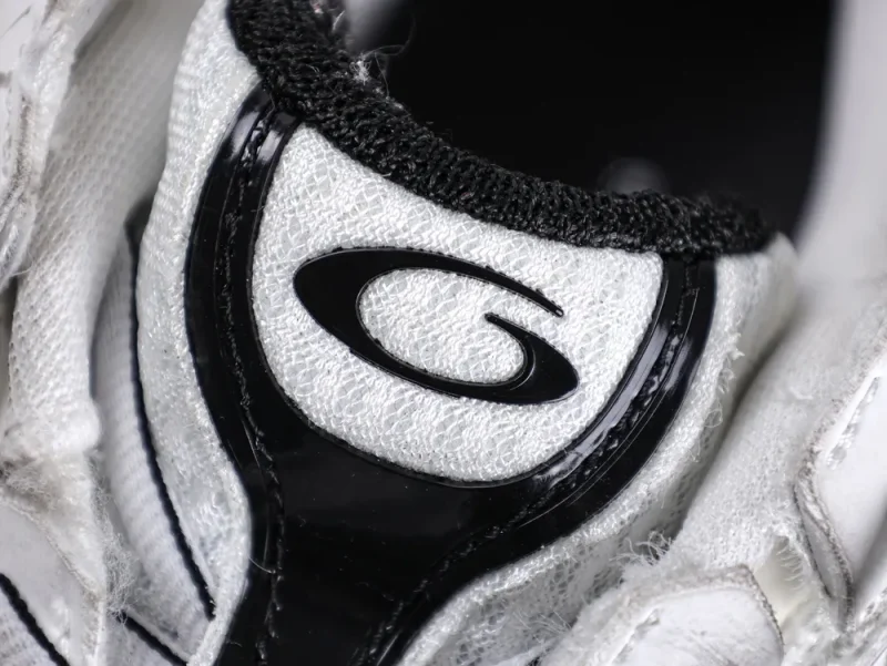 White fabric sneaker with black trim and logo detailing on the tongue.