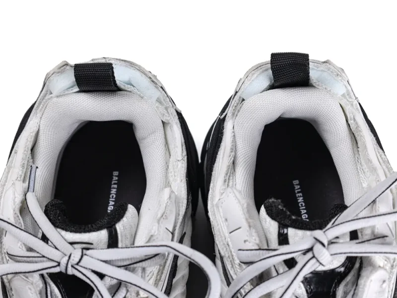 White and black sneakers with fabric lining and laces, top view.