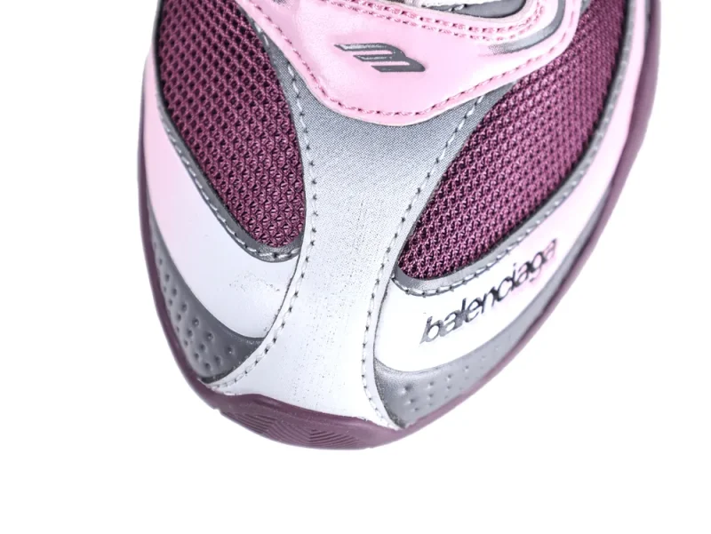 Close-up of a sneaker with pink, silver, and purple mesh and leather materials.