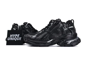 Black leather sneakers with mesh detailing and textured sole, featuring dynamic design elements.