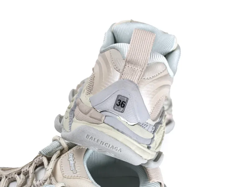 Light gray and beige sneaker featuring mesh fabric and rubber sole, focusing on heel.