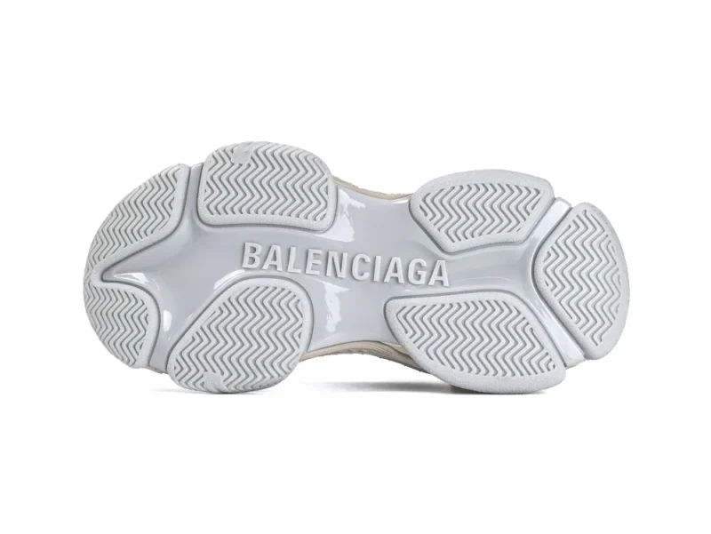 Grey rubber sneaker sole with embossed brand name, showcasing textured grip design.
