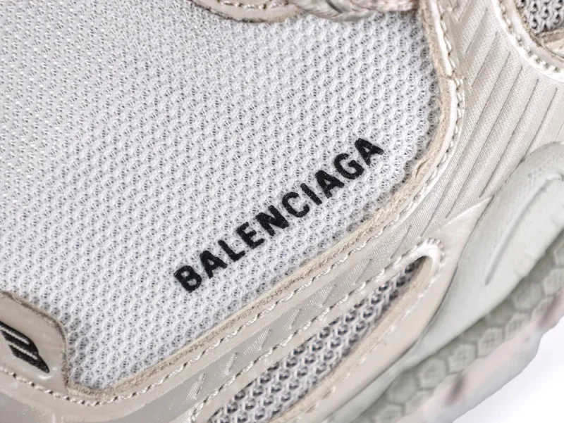 White mesh sneaker with beige leather accents and textured detailing.