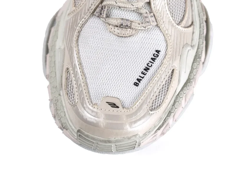 Silver and white mesh sneaker upper with metallic detailing and textured rubber sole.