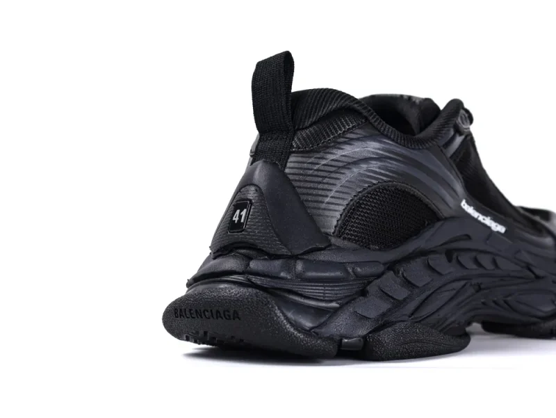 Black sneaker with synthetic material and textured sole, highlighting the size label.