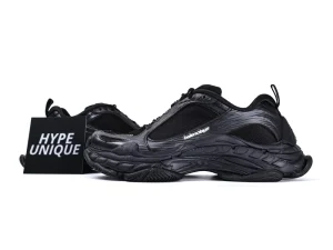 Black sneakers with mesh and synthetic upper, featuring a chunky textured sole.