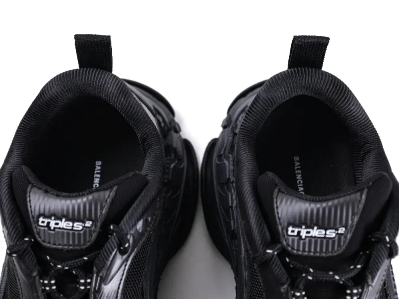 Black sneakers with mesh and leather details, featuring sturdy pull tabs.