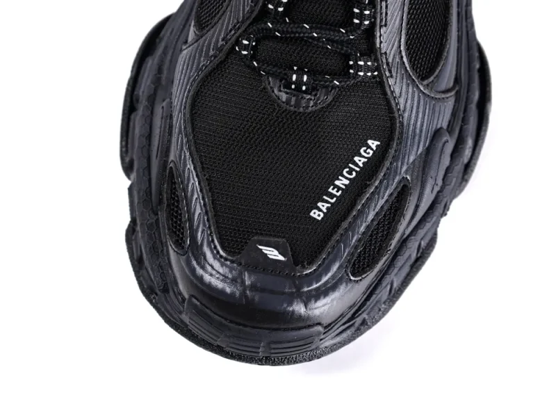 Black mesh and leather sneaker with textured design and white logo on the toe.