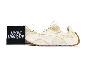 Beige sneakers with mesh fabric and leather accents, featuring a rubber sole.