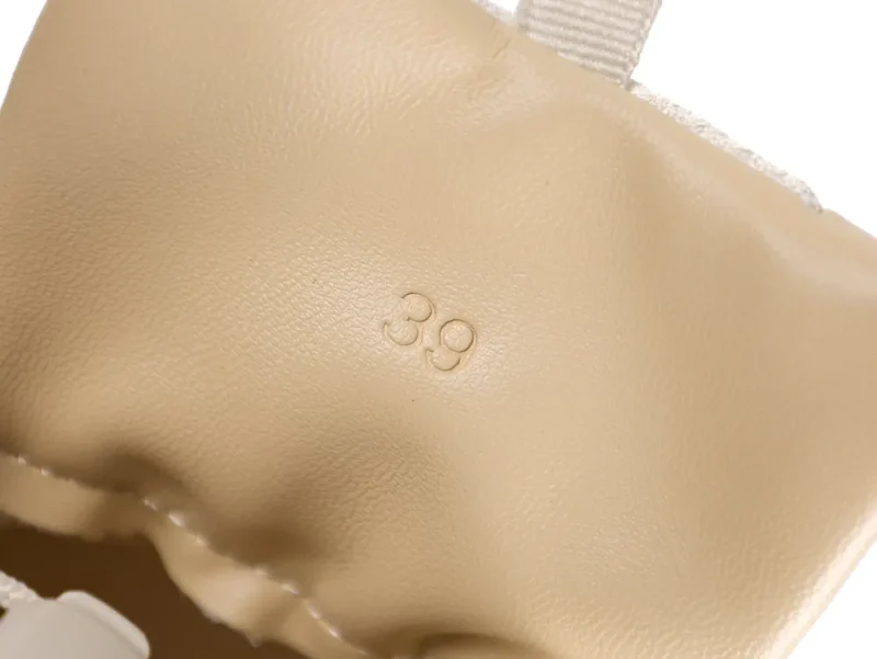 Beige leather product with embossed number 39, featuring fabric detail.
