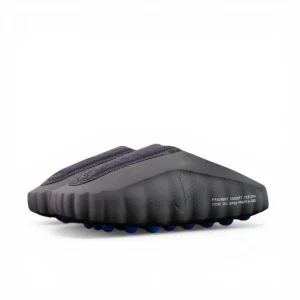 Black textured shoe with blue pebbled outsole, showcasing rugged design and materials.