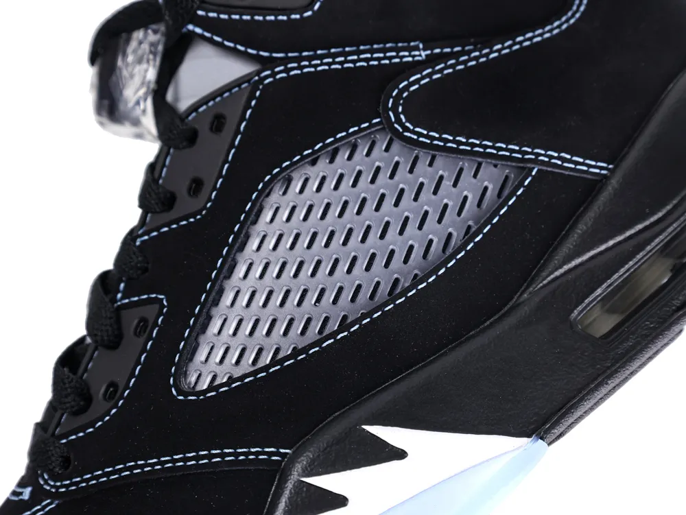 Close-up of black leather sneaker with blue stitching and gray mesh panel.