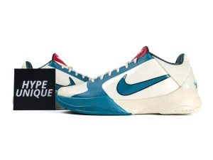 White and teal sneakers with synthetic material, featuring a prominent Nike swoosh.