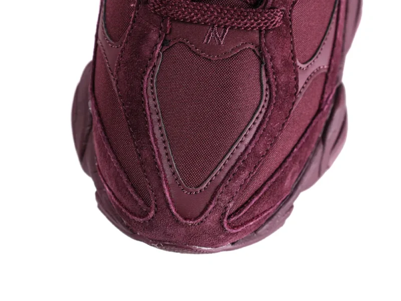 Close-up of maroon sneaker toe made of suede and fabric materials.