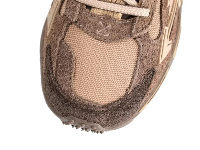 Close-up of a brown suede and mesh sneaker toe section with beige accents.