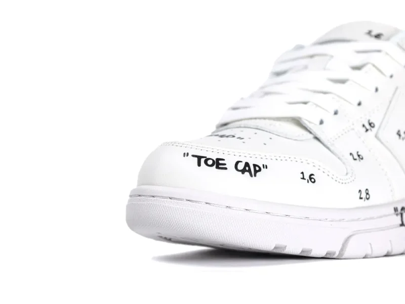 White leather sneaker with black text on toe cap and laces visible.
