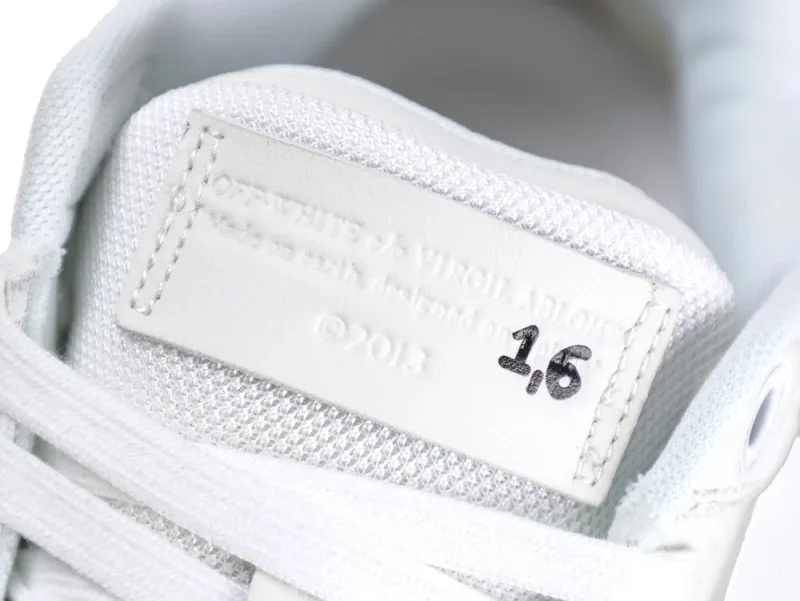 White leather tongue tag with textured detailing on a sneaker.