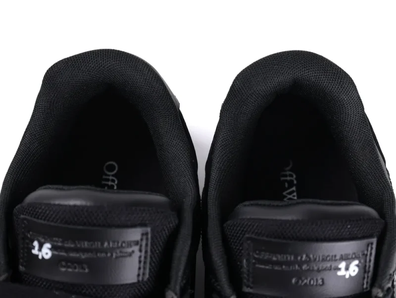 Black fabric sneakers with leather accents, featuring branding inside and on the tongue.