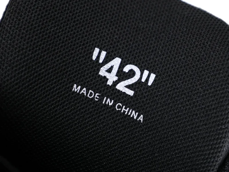 Black fabric material with "42" printed, likely part of a shoe, made in China.
