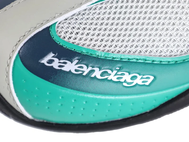 Macro shot of the "Balenciaga" logo printed on a textured green leather panel with perforated details.