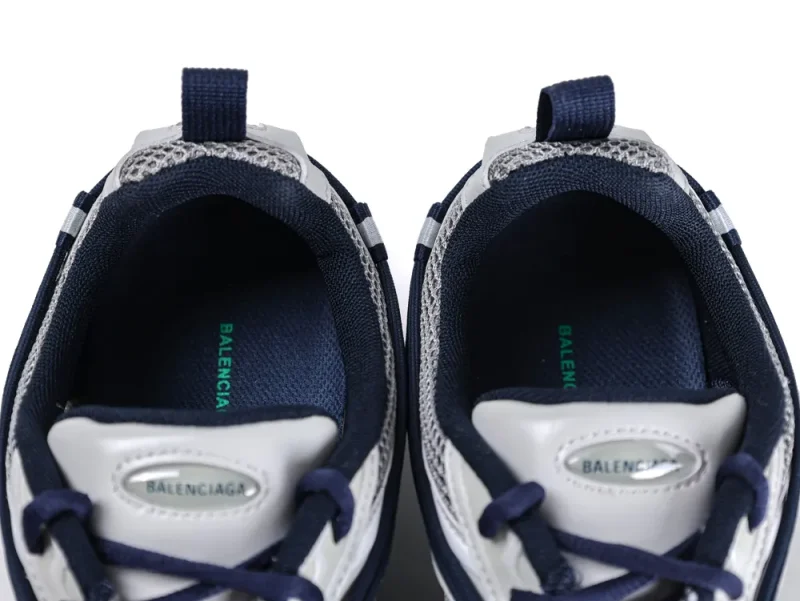 A pair of Balenciaga Radar Sneakers viewed from above, showing the navy blue mesh lining and green logo on the insoles.