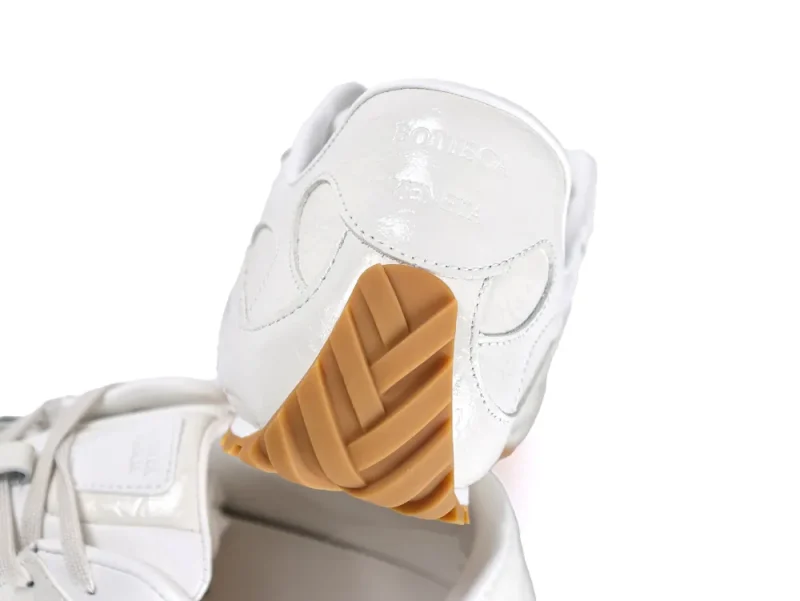 Heel view showing the embossed Bottega Veneta logo on cream leather and the wrap-up gum sole.