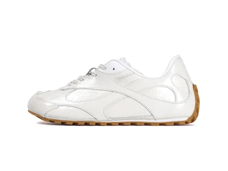 Medial side view of the left sneaker showing the slim athletic silhouette and gum rubber traction.