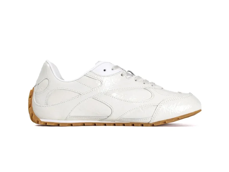 Side profile of the right Bottega Veneta Orbit Flash sneaker in cream patent leather with a gum sole.