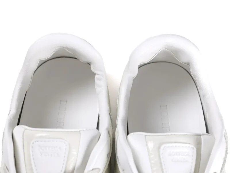 Top-down view showing the padded white leather ankle collar and dual tongue patches.
