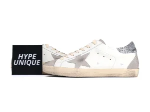 Side view of white Golden Goose sneakers with black branding card