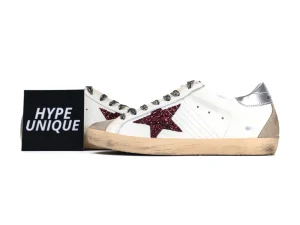 Pair of Golden Goose sneakers with burgundy glitter stars and logo card