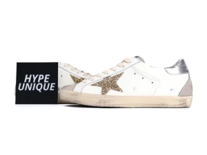 Side view of white Golden Goose sneakers with gold glitter star