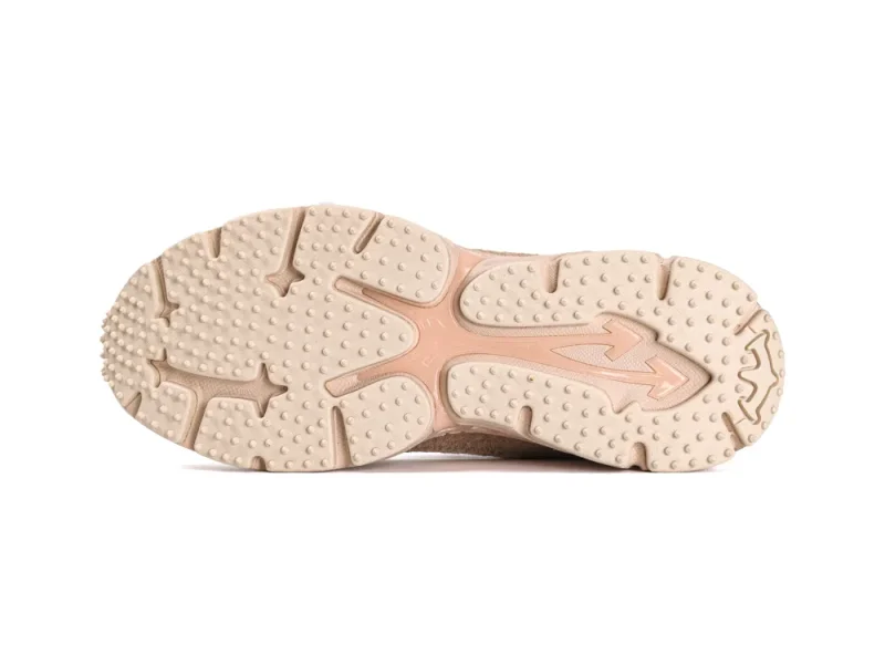 Full view of the spiked tan rubber outsole featuring the signature arrow design