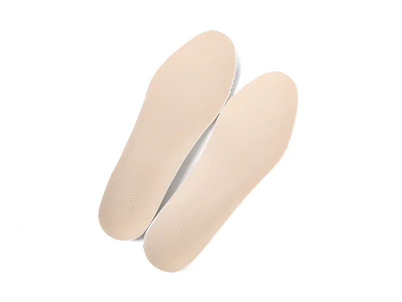 Pair of nude-colored insoles with the Off-White brand name printed in gold near the heel.