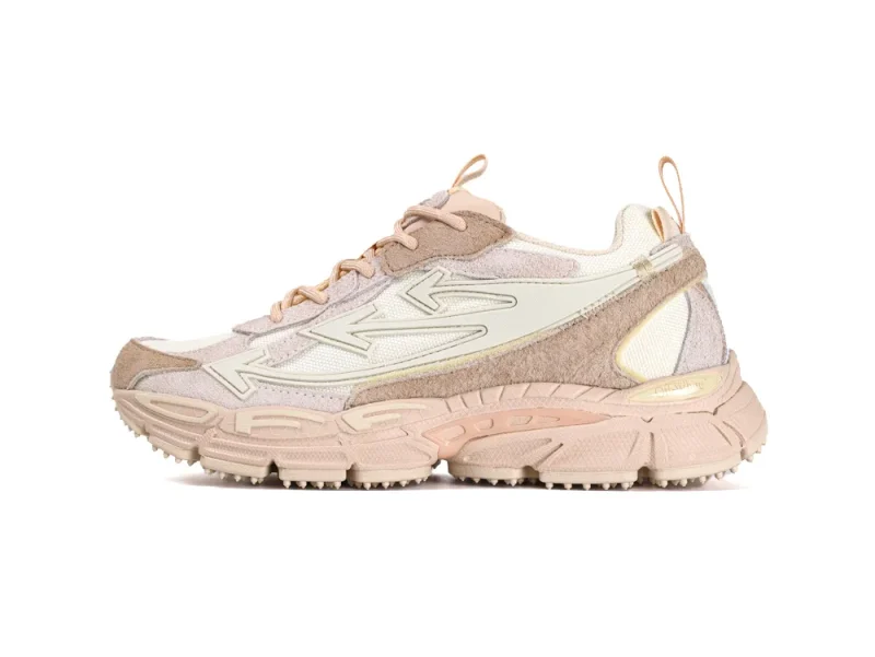 Medial side view of the left sneaker showing the complex stitching and various textures of the caramel and beige upper.