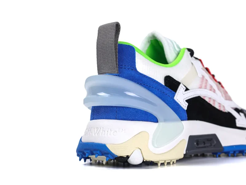 Multicolored sneaker with mesh and suede materials, featuring a blue heel and spiked sole.