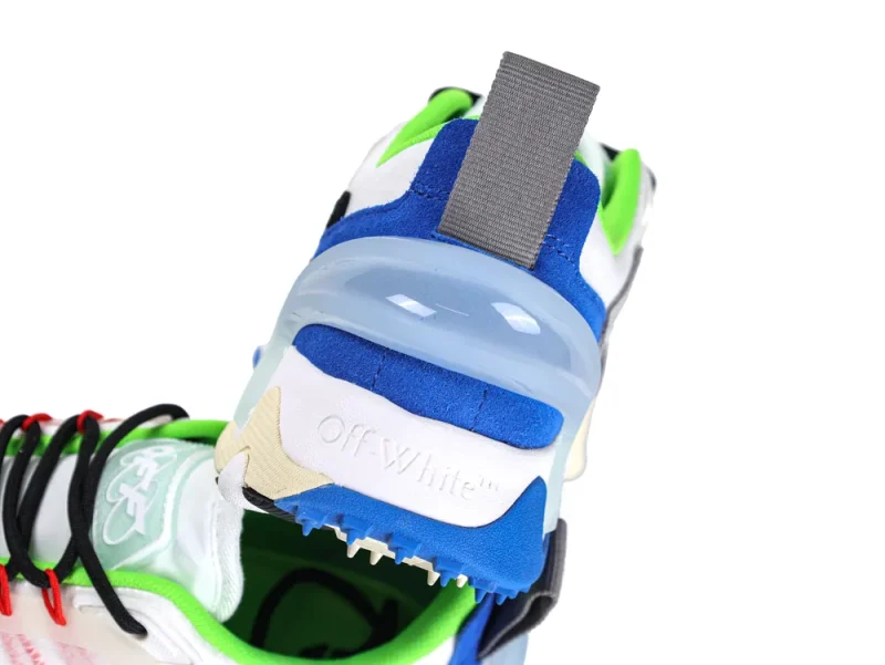 Sneaker heel featuring blue suede, green accents, and transparent plastic detailing with gray tab.