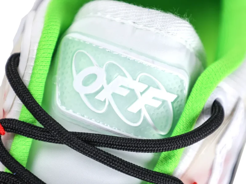 Close-up of sneaker tongue with white logo, lime green lining, and black laces.